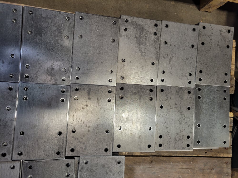Laser cut rectangular metal pieces punch cut with holes