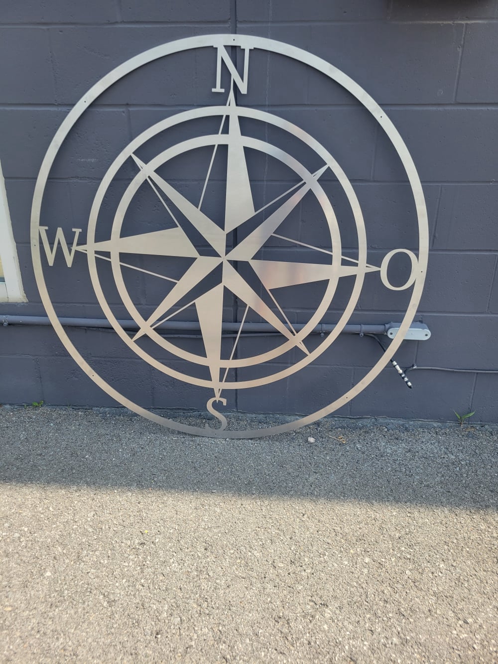Bright silver sign, laser cut with directional star